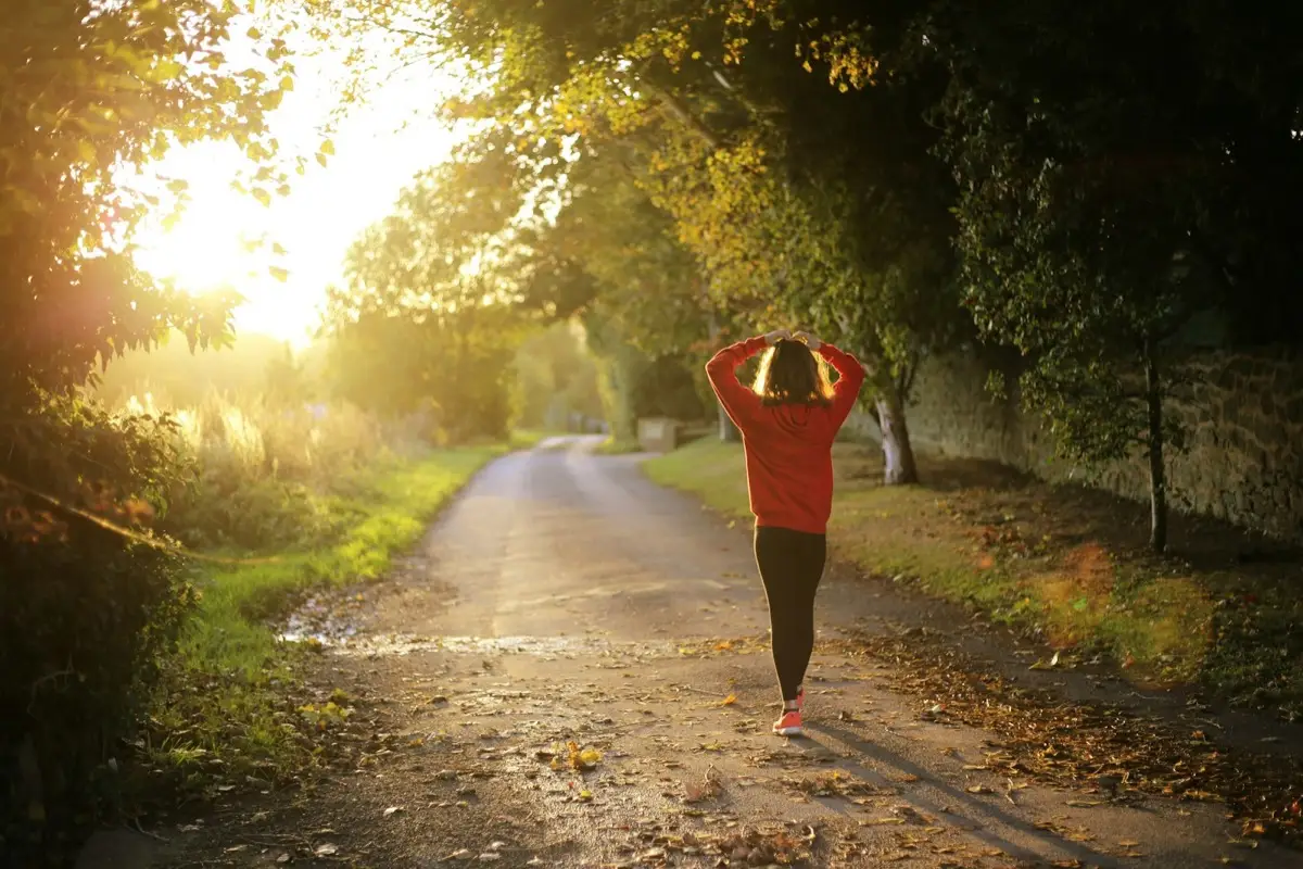 A person walking forward along an open path in soft daylight