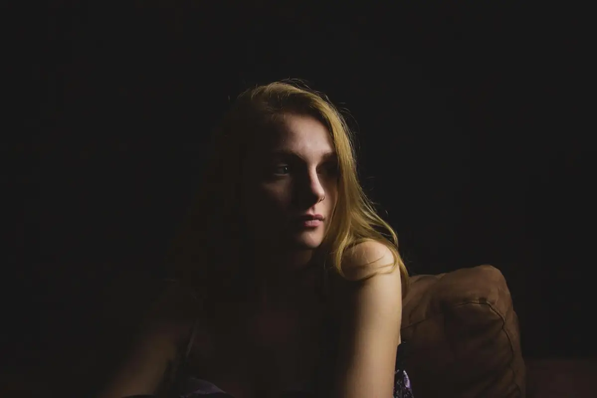 A person sitting quietly in soft light, taking a calm moment